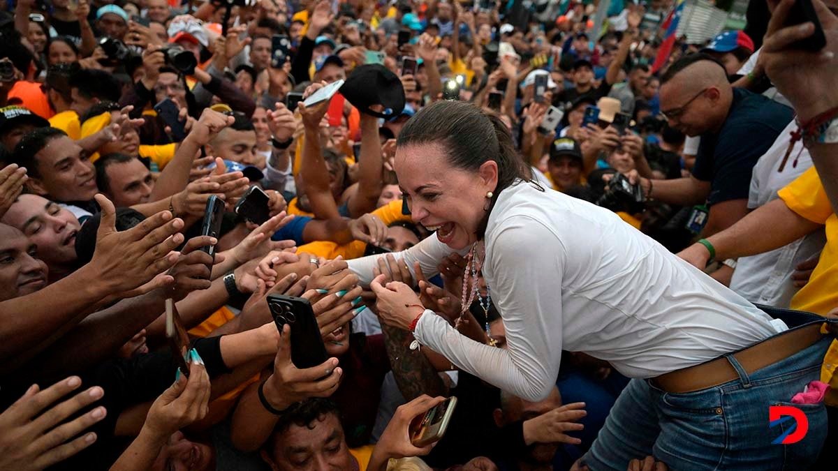 La líder de la oposición venezolana, María Corina Machado, saluda a sus seguidores durante un acto en Maracaibo. Foto: Juan Barreto / AFP.